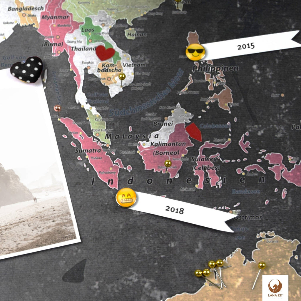 Dekoriere Deine Weltkarte Graphit mit Stickern, Pins und Fotos.